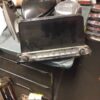 A laptop sitting on top of some metal parts.