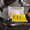 A yellow piece of paper on top of a computer.