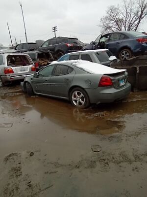 A car parked in the middle of a flooded parking lot.