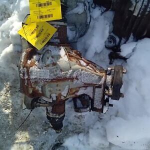 A rusted out car in the snow with some tags on it.