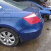 A blue car parked in the mud next to other cars.