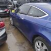 A blue car parked in the middle of a parking lot.