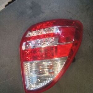 A red and white car tail light on the floor