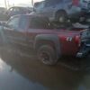 A red pick up truck parked in the rain.