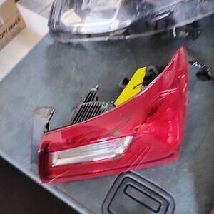 A red car 's tail light is broken and sitting on the table.