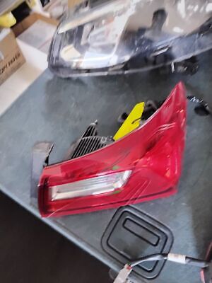 A red car 's tail light is broken and sitting on the table.