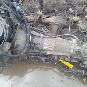 A car engine and other parts in the mud.