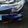 A blue car that has been smashed in the middle of it.