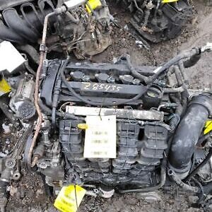 A pile of old engines and parts in the dirt.