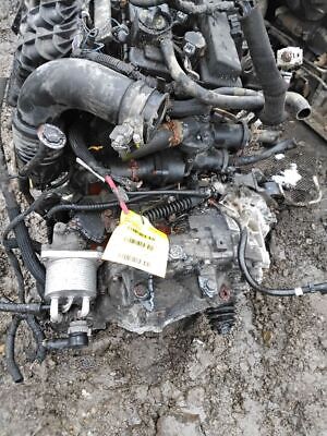 A car engine that is broken down and laying on the ground.