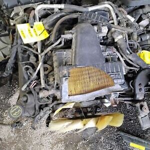 A pile of old car parts that are in the dirt.