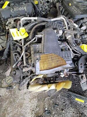 A pile of old car parts that are in the dirt.