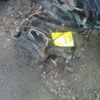 A broken car engine and other parts on the ground.