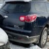 A black car parked in the snow with its rear lights on.