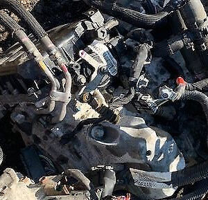 A pile of old car parts in the dirt.