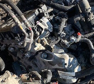 A pile of old car parts in the dirt.