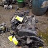 A pile of old engines and parts on the ground.