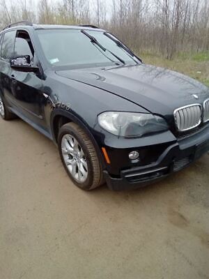 A black bmw parked on the side of a road.
