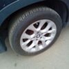 A car tire on the ground near another car.
