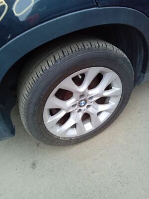 A car tire on the ground near another car.