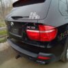 A black bmw parked on the side of a road.