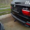 A black bmw parked in the middle of a driveway.