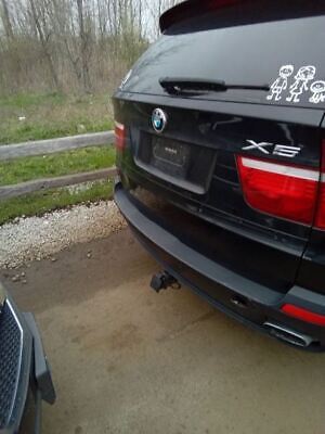 A black bmw parked in the middle of a driveway.