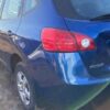 A blue car parked on the side of a road.