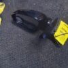 A black object laying on the ground with yellow tags.