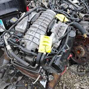 A car engine sitting on top of rubble.