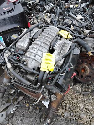 A car engine sitting on top of rubble.