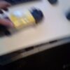 A blurry picture of someone holding something on the stove.