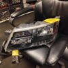 A car headlight sitting on top of a black chair.