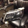A car headlight sitting on top of a black chair.