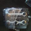 A car stereo with two wrenches wrapped in plastic.