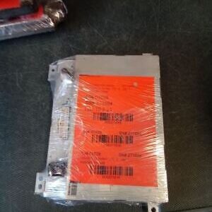 A car battery with some orange stickers on it