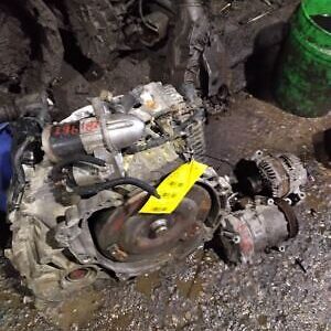 A car engine and other parts on the ground.