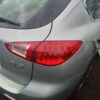 A silver car with its rear lights on.