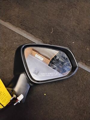 A side view mirror of a motorcycle on the street.