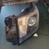 A headlight that is broken and sitting on top of a table.
