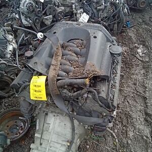 A pile of old car parts sitting in the dirt.