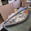 A car headlight that is broken and sitting on the table.