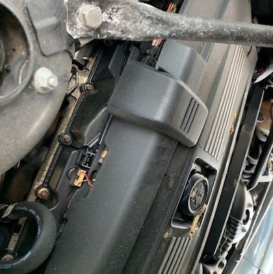 A car engine with the hood open and some parts missing.