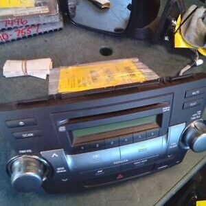 A radio is sitting on the floor next to some papers.