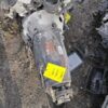 A metal object with yellow tags on it.