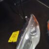 A car headlight with the yellow tag on it.