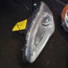 A car headlight with the yellow tag on it.