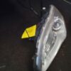A car headlight with the yellow tag on it.