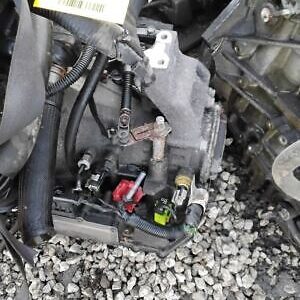 A motorcycle engine is shown in the gravel.