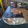 A car headlight sitting on top of cardboard.